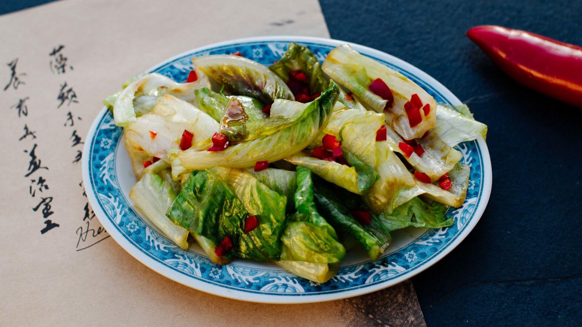 Romanasalat aus dem Wok mit Knoblauch & Chili: Im Wok gebratener Salat ist in China ein beliebtes Gericht zu besonderen Anlässen wie Neujahr, Geburtstagen oder Abschlussfeiern – denn das kantonesische Wort „saang choi“ (Salat) klingt wie...