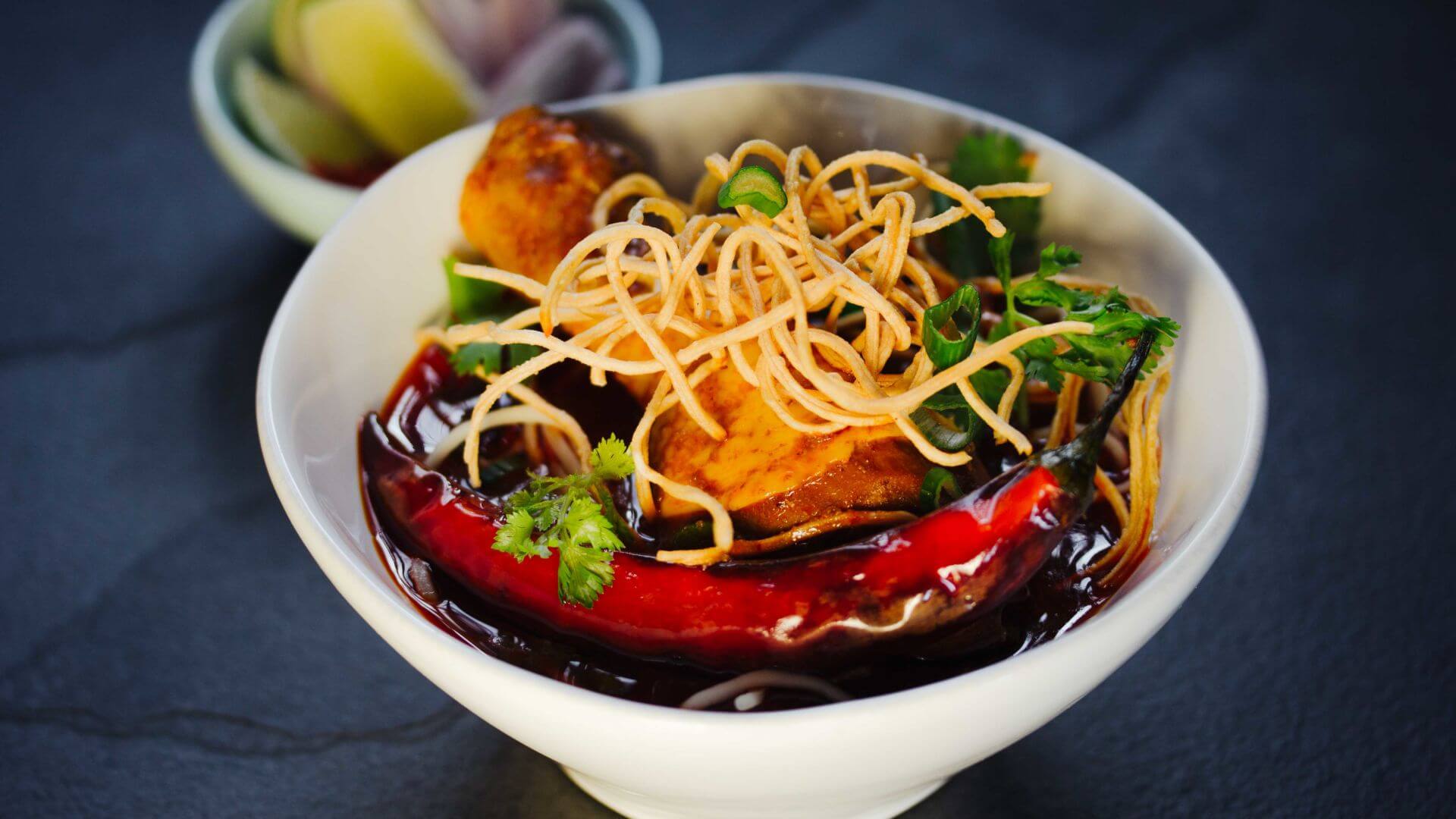 Khao Soi - Curry Nudeln aus Chiang Mai: Khao Soi ist die aromatische Nudelsuppe aus Chiang Mai, die mit zartem Hähnchen, cremiger Currysauce und knusprig frittierten Nudeln die perfekte Balance zwischen Wärme, Würze und Textur findet. 🍜 Schwarzer...