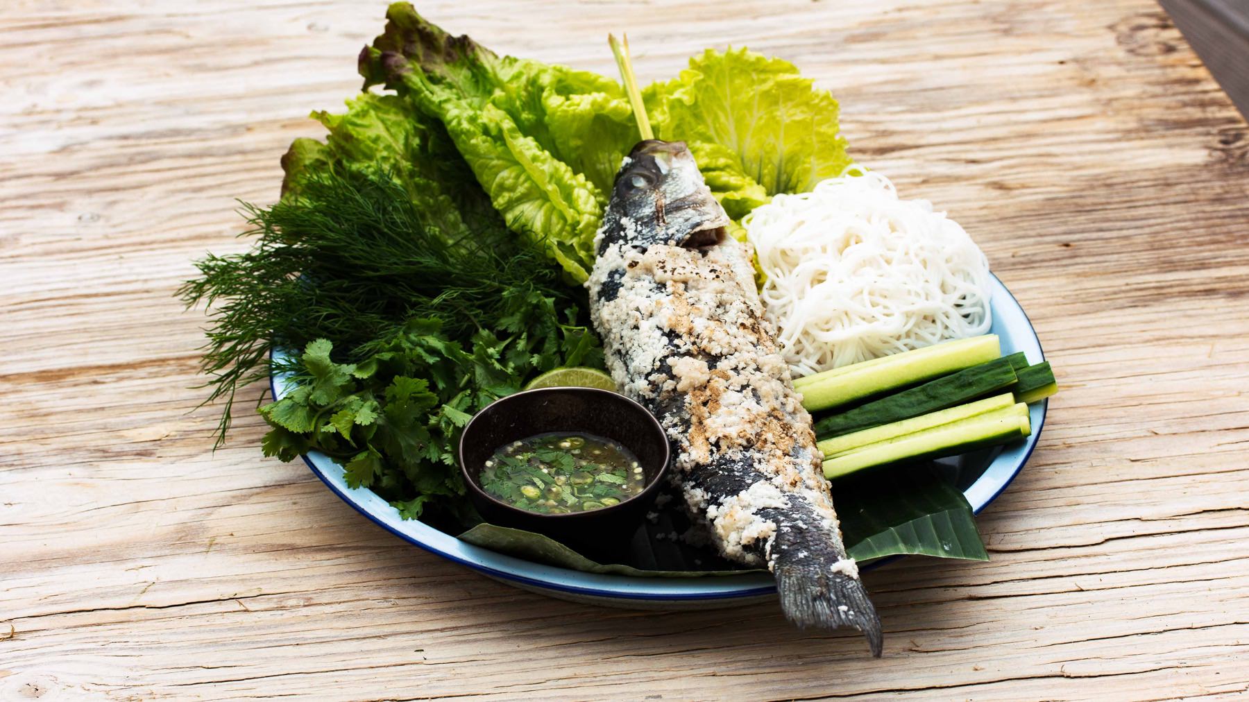 Gegrillter Fisch in Salzkruste mit Zitronengras - Plaa Phao Kleua: Fisch in Salzkruste ist bei uns bekannt – in Thailand bekommt er jedoch einen ganz eigenen Dreh: gefüllt mit Zitronengras, in dünner Kruste gegrillt und serviert mit einer...