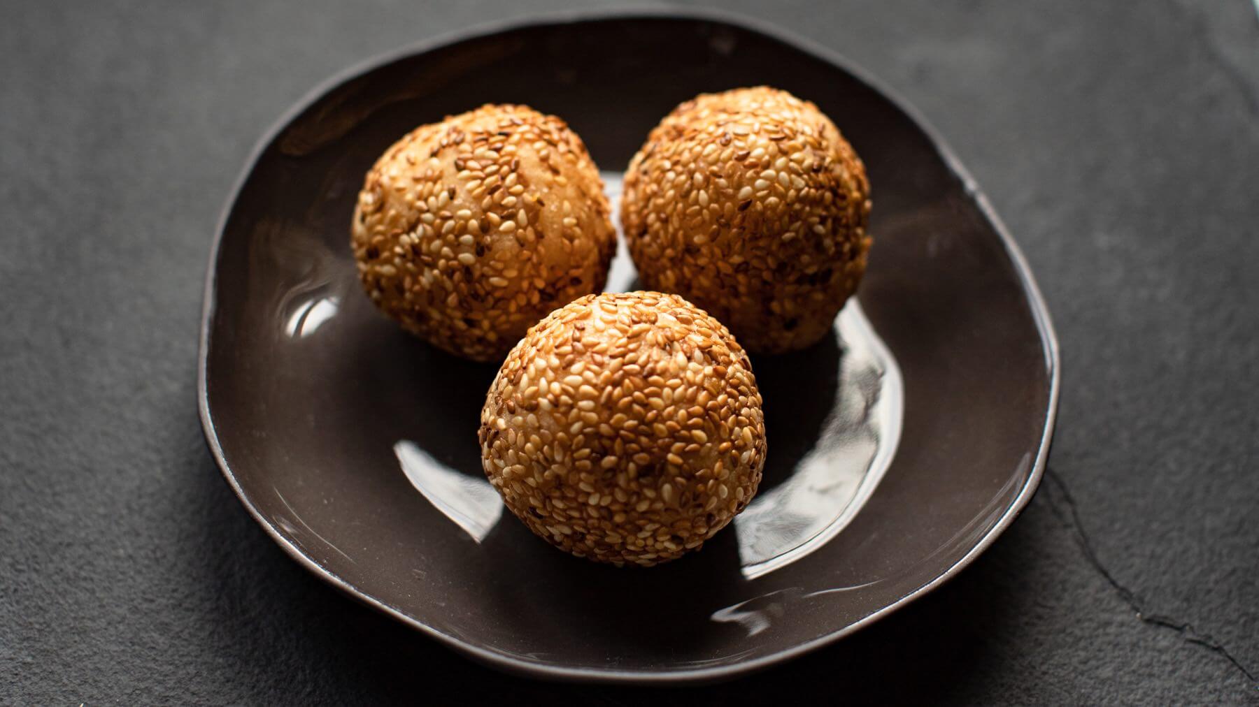 Sesambällchen aus Vietnam: Banh Cam – goldene, frittierte Teigbällchen mit einer süßen Füllung aus roter Bohnenpaste, umhüllt von knusprigem Sesam – sind ein beliebter vietnamesischer Snack, der perfekt zu einer Tasse Tee passt oder einfach für...