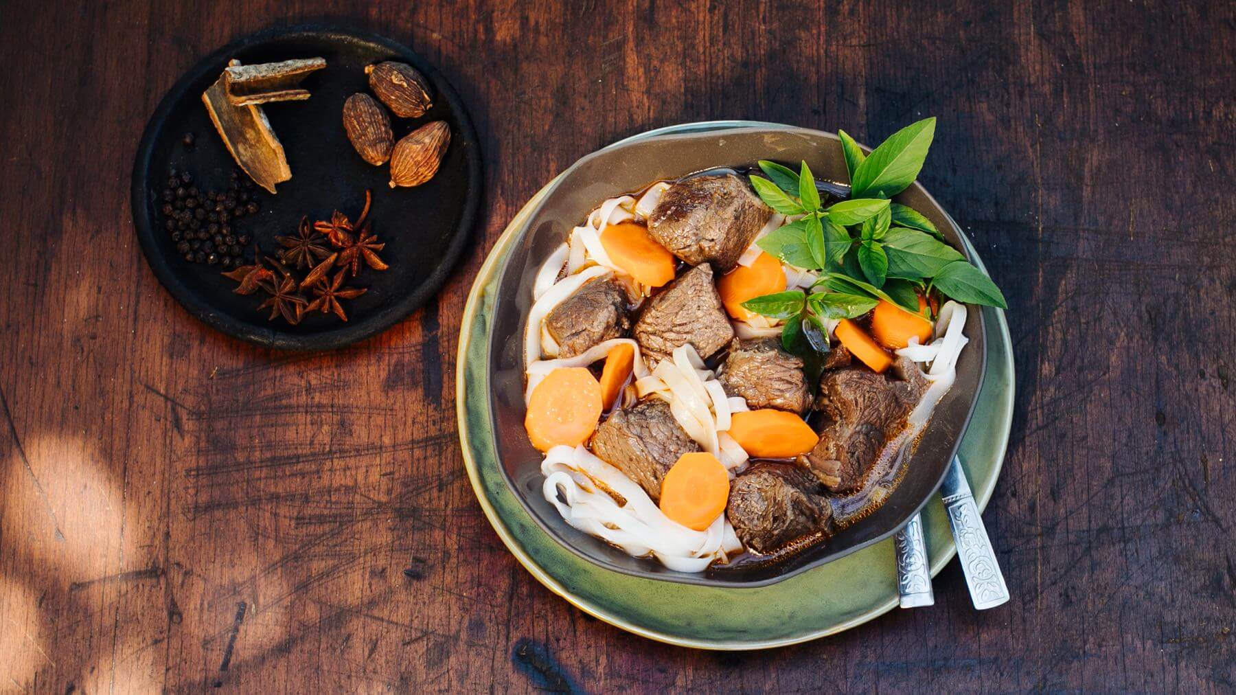 Geschmortes Rindfleisch mit Reisbandnudeln und Schwarzem Kardamom: Bò Kho mit Rotwein ist Vietnams Antwort auf Boeuf Bourguignon – langsam geschmortes Rindfleisch, gewürzt mit Sternanis, Zimt und Schwarzem Kardamom, verfeinert mit Rotwein und...