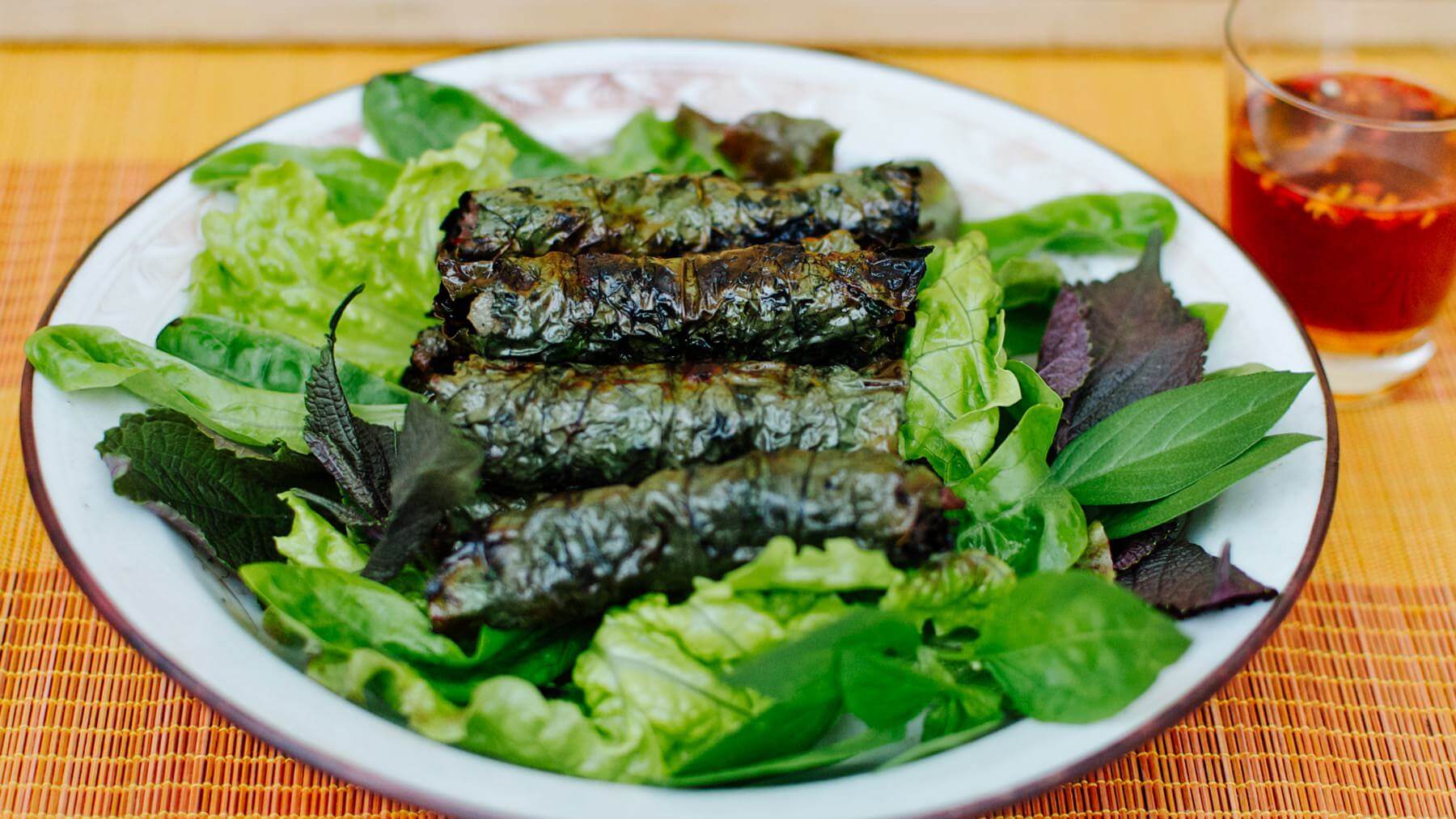Rindfleisch im Lot-Blatt: Bò Lá Lốt ist ein echter Klassiker der vietnamesischen Straßenküche: Zart gewürztes Rindfleisch, vermischt mit etwas Schweinefett für Saftigkeit, wird in saftig-grüne Betelblätter (Lá Lốt) gewickelt und über Holzkohle...