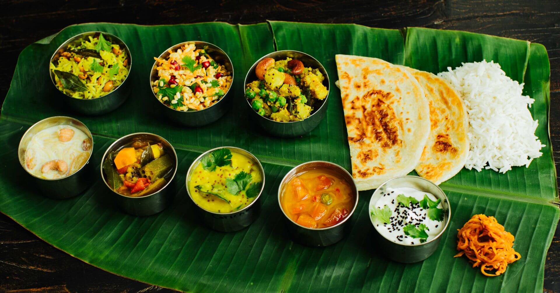 Südindisches Thali auf dem Bananenblatt: Thali ist ein echtes Fest der Aromen – bunt, vielfältig und rundum sättigend. Auf einem großen Teller - Thali - oder Bananenblatt serviert, erwarten dich kleine Schälchen mit Curry, Gemüse, Sambar, Rasam,...