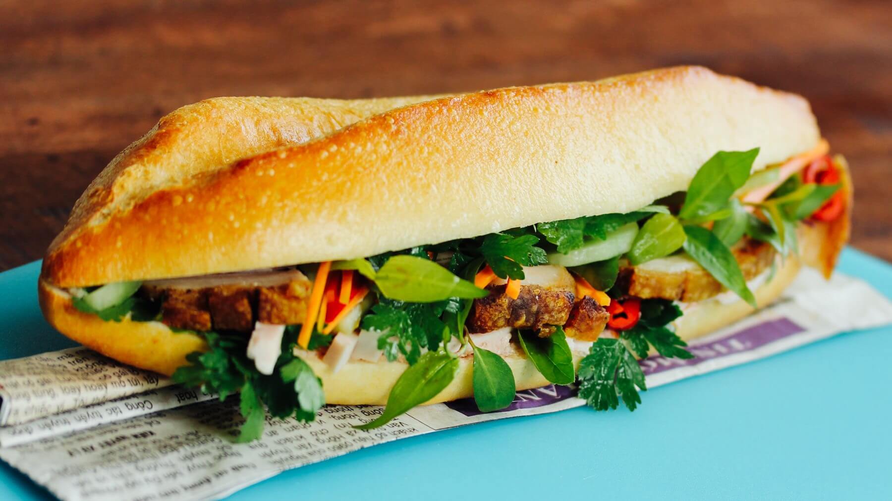 Sandwich á la Vietnam - Banh Mi: Bánh Mì ist Vietnams Antwort auf das französische Baguette – außen knusprig, innen luftig, gefüllt mit gegrilltem Schweinefleisch, Pastete, Wurst, frischen Kräutern und Salat. 🌶️ Verfeinert mit Chili- und...
